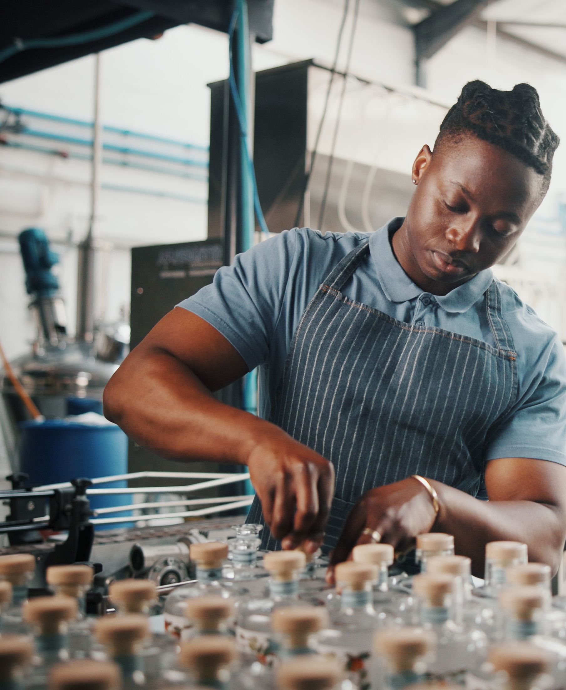 Distillery, bottle and logistics with man in factory for packaging, assembly line and supply chain inspection. Manufacturing, inventory and distribution with person in warehouse for quality control